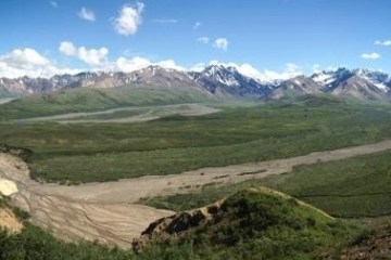 Mountainous range and green fields