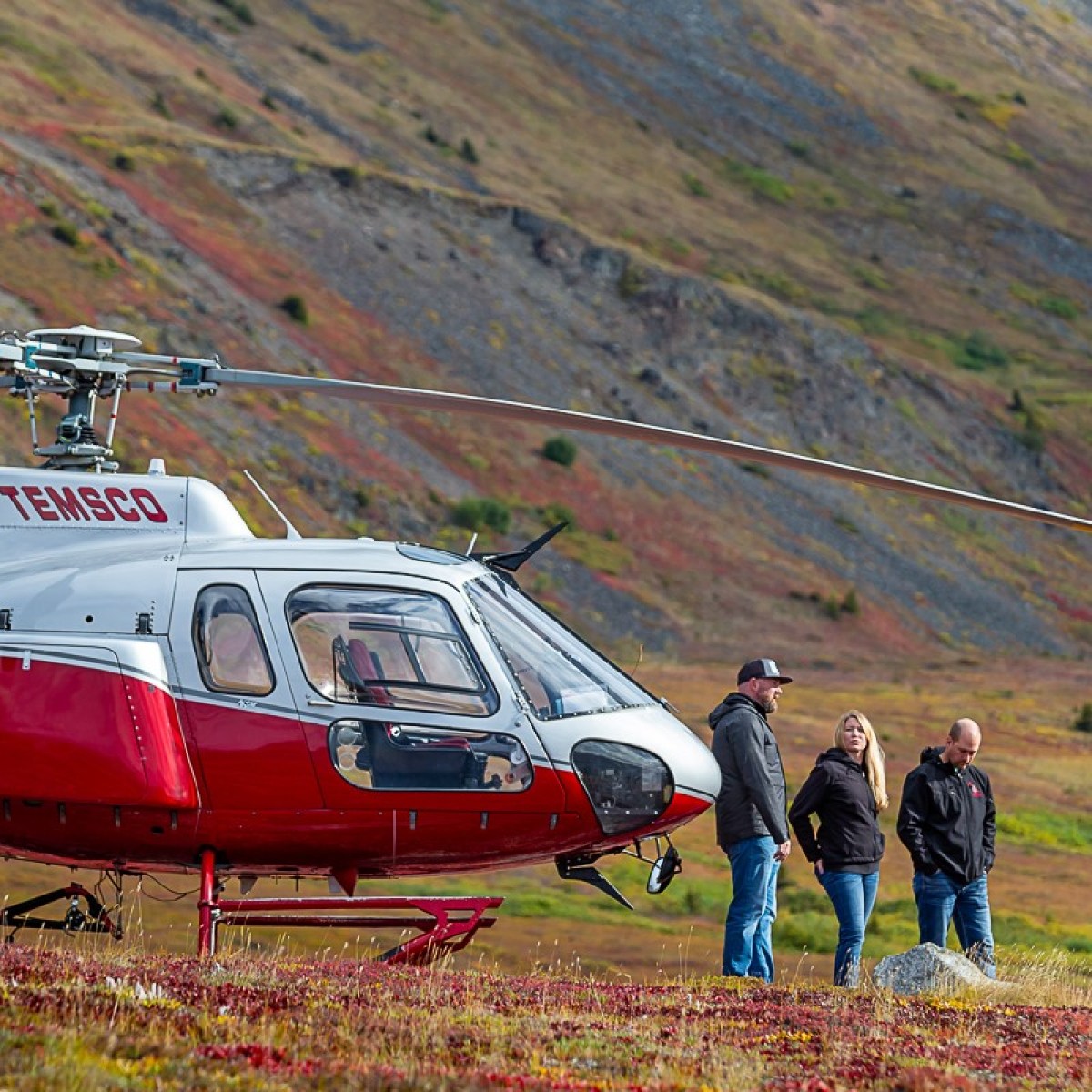 a helicopter parked on a grassy hill