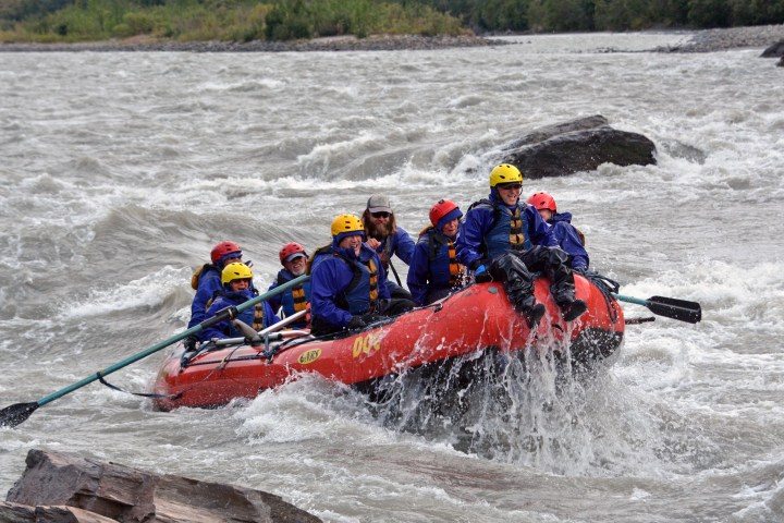 Friends rafting among rapids